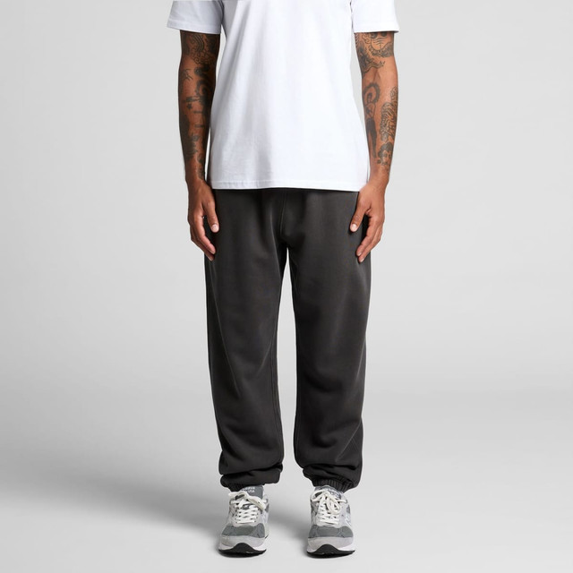 Faded track pants in dark grey, featuring an elastic waistband and cuffed ankles, worn with a white t-shirt.