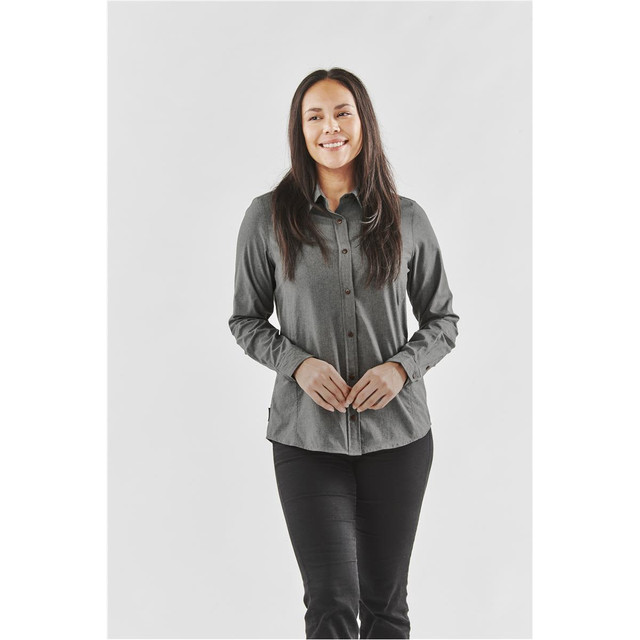 A button-up shirt in dark grey worn by a smiling woman, featuring a logo on the design.