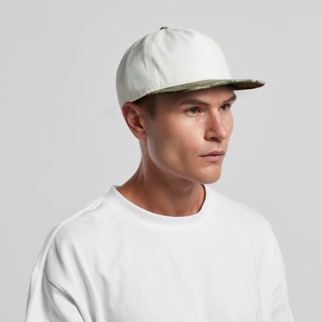 A two-tone camo cap featuring a white top and a camo pattern on the brim, worn by a model.