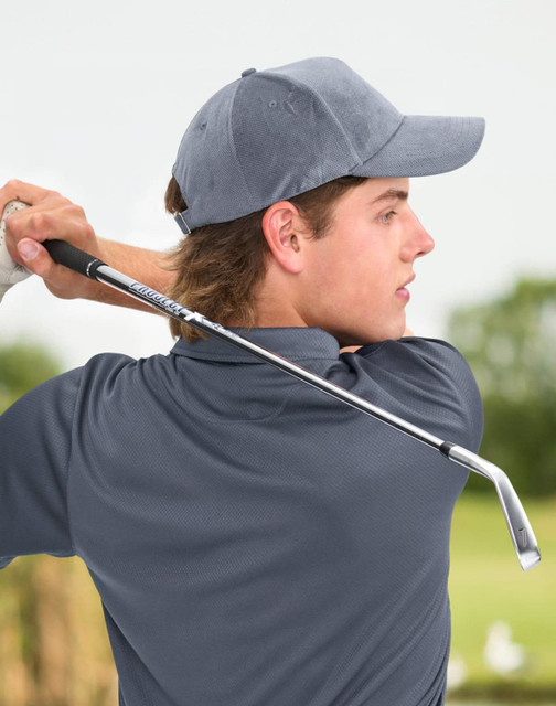 A young man wearing a grey jacquard texture 5-panel cap, holding a golf club in a lush outdoor setting.