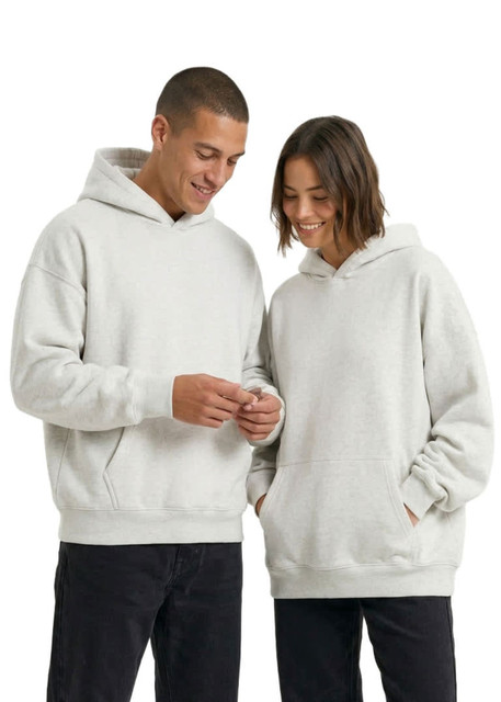Two people wearing oversized hoodies in a light grey colour, featuring front pockets and hoods. The image includes a logo.