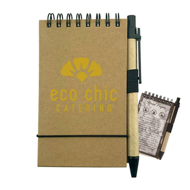 A brown stone paper notebook with a spiral binding, accompanied by a black pen and featuring a small notepad.