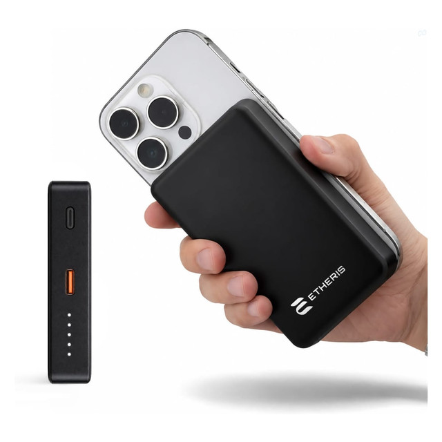 A black solid-state power bank is held next to a smartphone, featuring a small LED indicator and a logo.