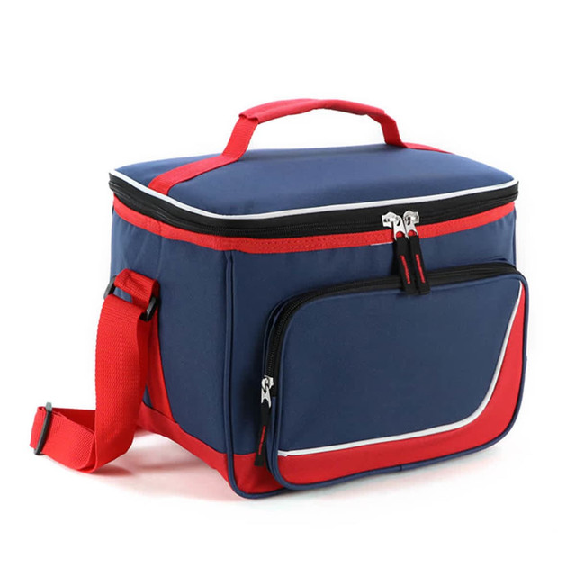 A navy blue and red cooler bag with a zippered top, a front pocket, and a detachable shoulder strap. It has a logo.