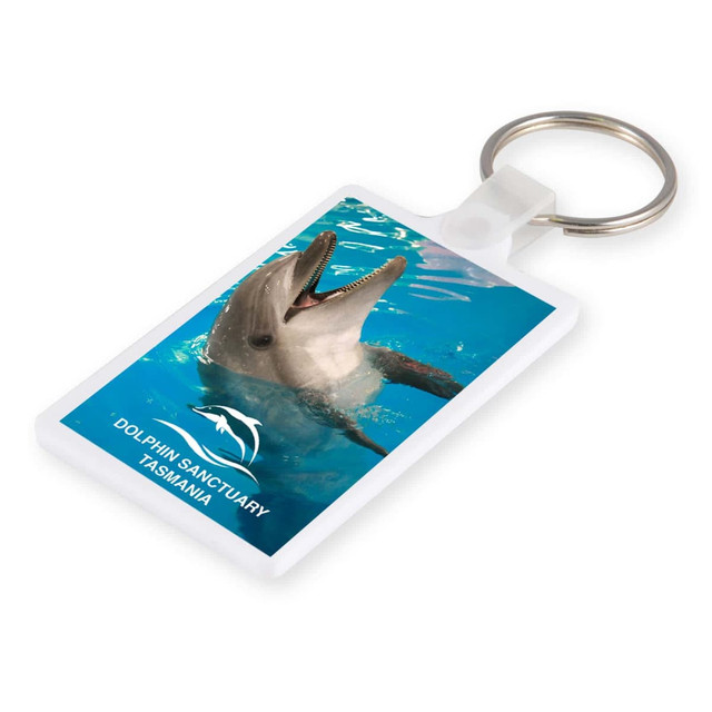 A white keytag featuring a dolphin swimming in blue water, with a logo at the bottom.