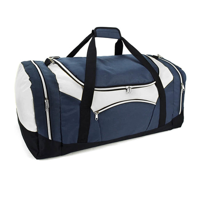 A duffle bag in navy blue and white, featuring multiple zippered pockets and a shoulder strap. It has a logo.