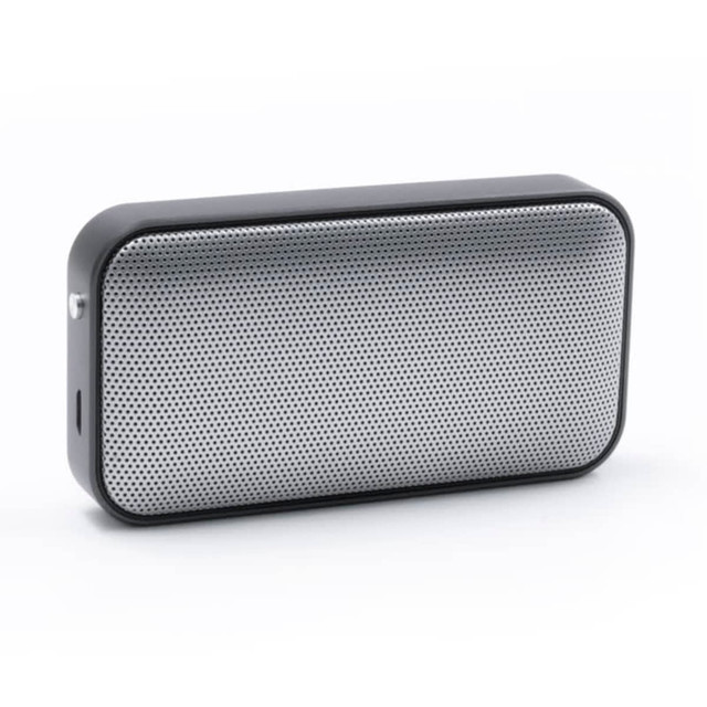 A compact black and silver wireless speaker with a mesh front design and a side port. It features a logo on the surface.