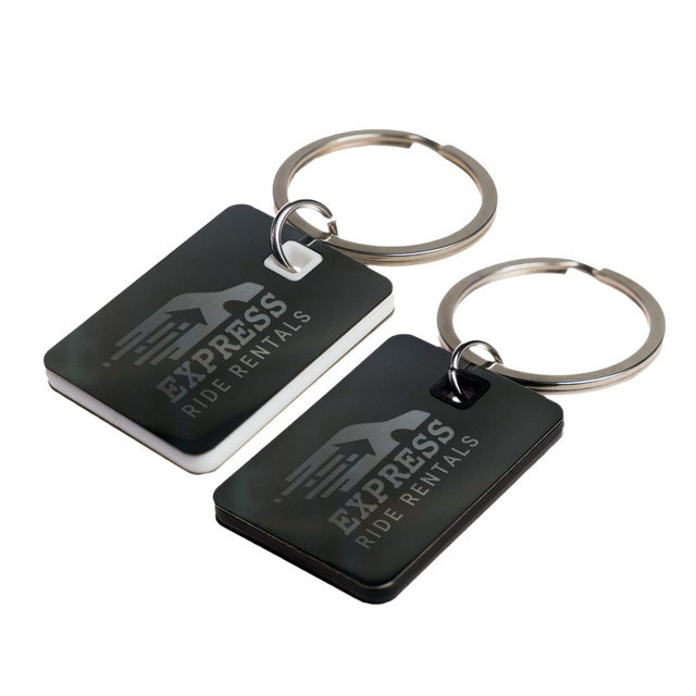A pair of rectangular stainless steel keytags, one black and one white, both attached to key rings.
