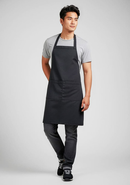 A black apron worn by a man, featuring a simple design and a front pocket, with a logo visible.