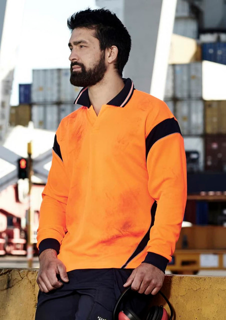 A long sleeve polo shirt in bright orange with navy accents, featuring a logo and worn by a man at a worksite.