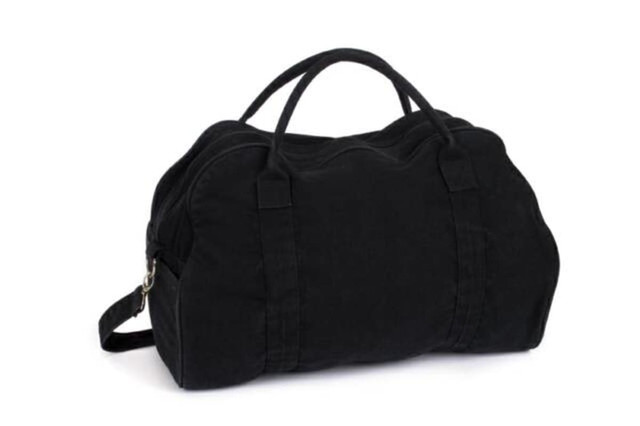 A black duffle bag with curved design and dual handles, featuring an adjustable shoulder strap and a logo.