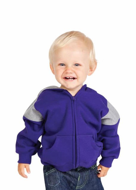 A smiling toddler in a purple hoodie with grey panels and jeans, walking against a plain white background.