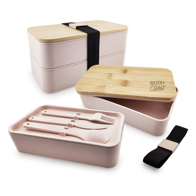 A stackable lunch box in pink with a bamboo lid and utensils, secured by a black strap. It features a logo.