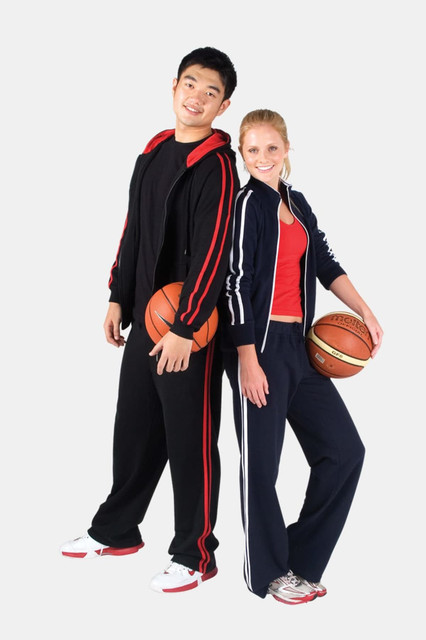 A pair of models wearing women's striped track pants in navy blue and red, each holding a basketball.