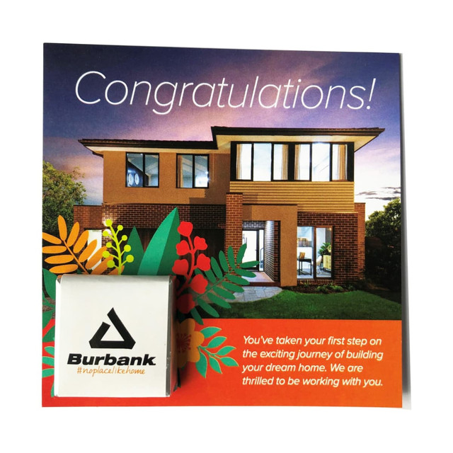 A card featuring a modern home image, with a small branded item in the corner. The card includes colourful floral designs.