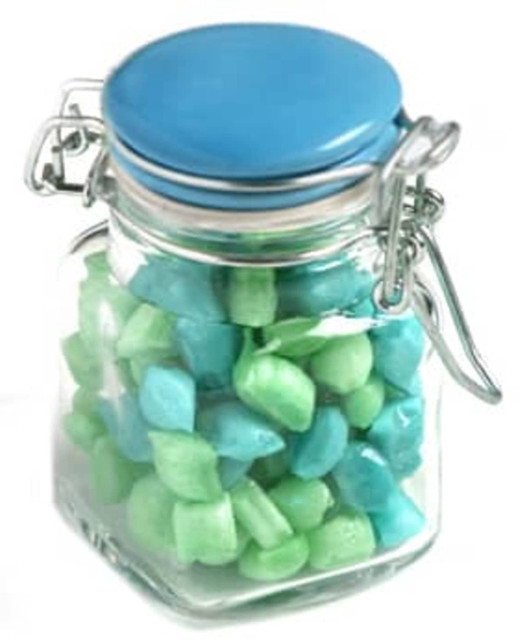 A glass clip lock jar filled with blue and green humbugs. The jar features a blue lid and a metal clasp.