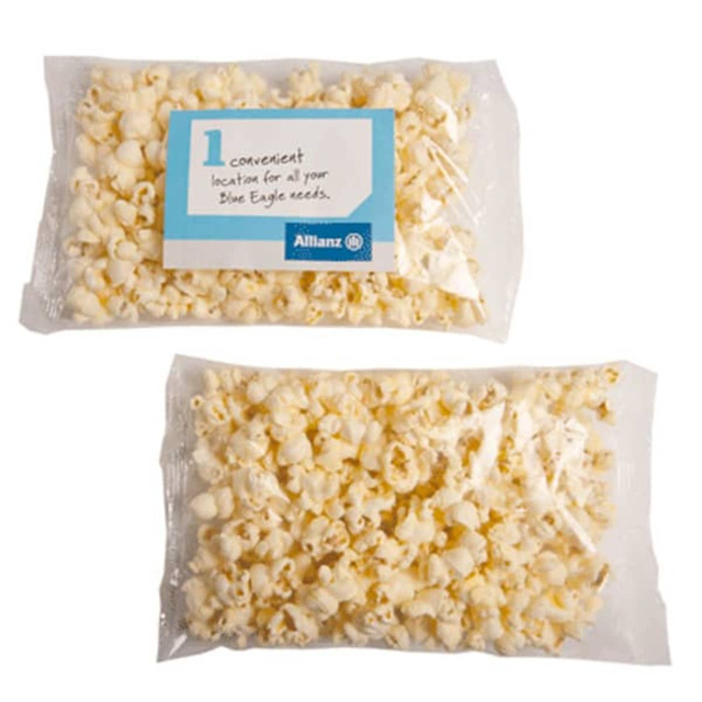 A clear plastic bag containing light yellow buttered popcorn, featuring a logo on the packaging.