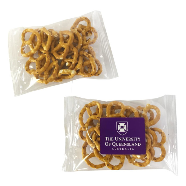 A clear plastic packet containing small, golden-brown pretzels, featuring a logo on the front.