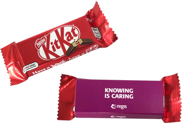 A red KitKat chocolate bar wrapped in a sleek sleeve, featuring a purple side with text.