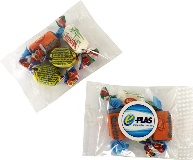 Mixed lollies in a clear packaging, featuring colourful sweets in various shapes and wrappers. Includes a logo.