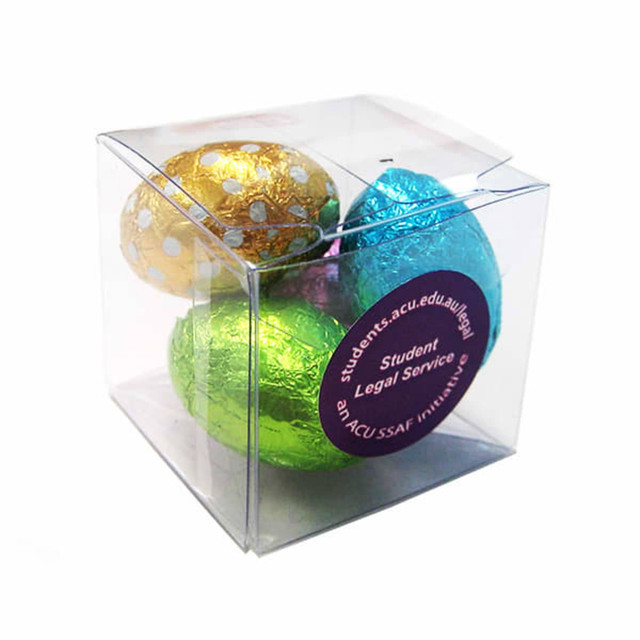 A clear cube containing mini chocolate Easter eggs in gold, blue, green, and pink foil.