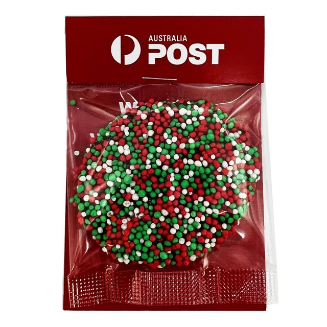 A round confectionery item with red, green, and white speckles, packaged in a clear bag with a logo.