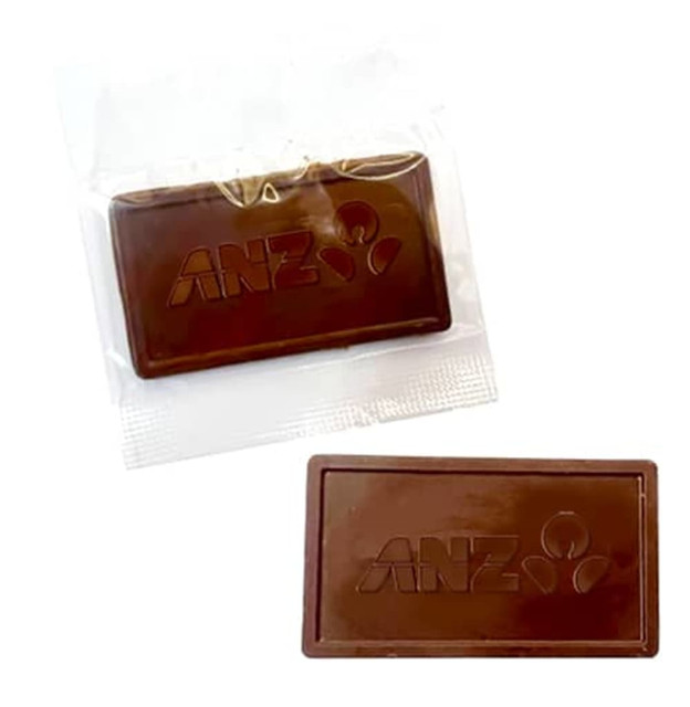 An embossed chocolate bar in dark brown, packaged in a clear wrapper, featuring a logo.