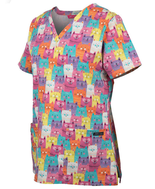 A colourful ladies scrub top featuring a playful cat print in various hues, with a logo on the side.