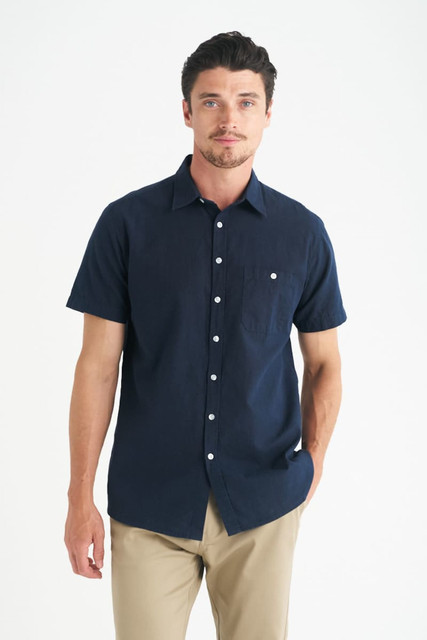 A men's short sleeve shirt in navy blue with a pocket and button-up design. Features a logo on the chest.