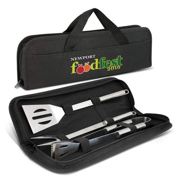 A black BBQ tool set case containing stainless steel spatula, tongs, and basting brush with a logo on the front.