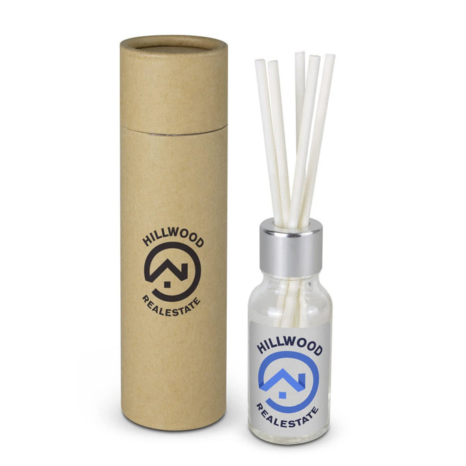 A scented diffuser in a clear glass bottle with white reeds, packaged in a cylindrical brown box, featuring a logo.