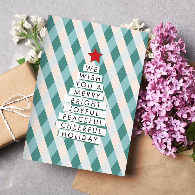A gift card featuring a tree design in teal and cream with a red star, surrounded by flowers and an envelope.