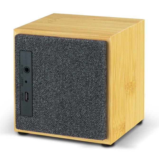 A square Bluetooth speaker in bamboo finish with a grey felt front, featuring input and reset buttons on the side.