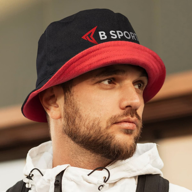 A reversible bucket hat in navy and red, featuring a logo on the front. Ideal for adding style to outdoor outfits.