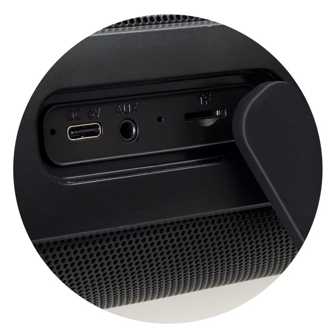 A close-up of a black Bluetooth speaker showcasing USB-C, AUX, and TF card ports. The speaker features a textured surface.