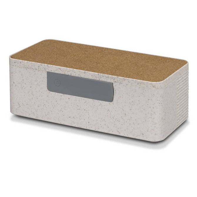 A wireless charger and speaker combination in off-white with a cork top and a grey button. It features a minimalist design.
