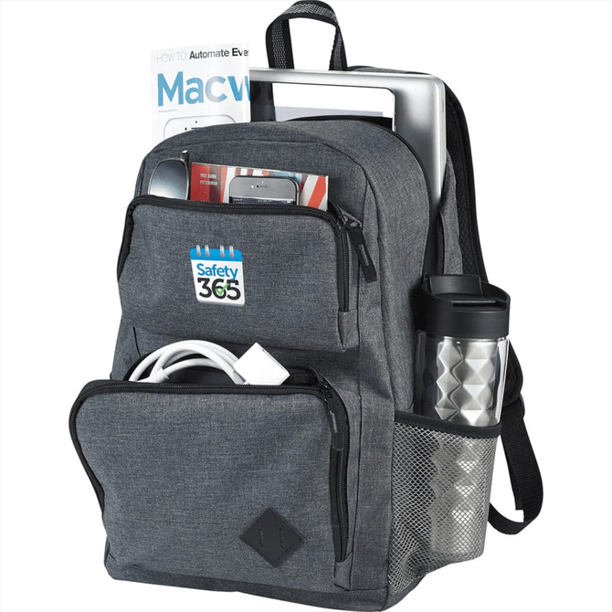 A grey backpack with multiple compartments, holding a laptop, phone, cables, a drink bottle, and magazines.