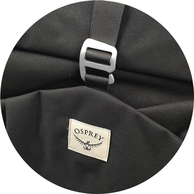 A black Osprey Arcane Roll Top Backpack featuring a metal buckle and a branded label on the side.