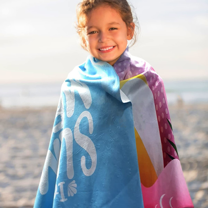 A young girl wrapped in a vibrant blue and pink beach towel with a playful design and a logo.