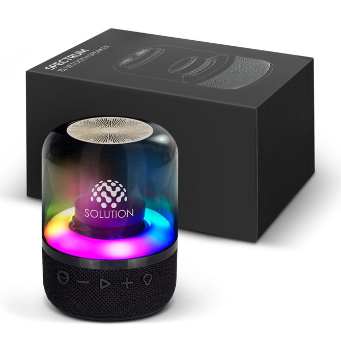 A Bluetooth speaker with a black base and a multicoloured LED light dome, alongside its black packaging.