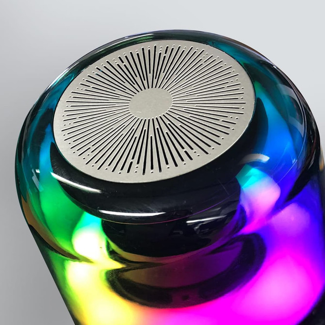 A Bluetooth speaker with a sleek, rounded design featuring vibrant, multicoloured lights and a metallic speaker grill on top.