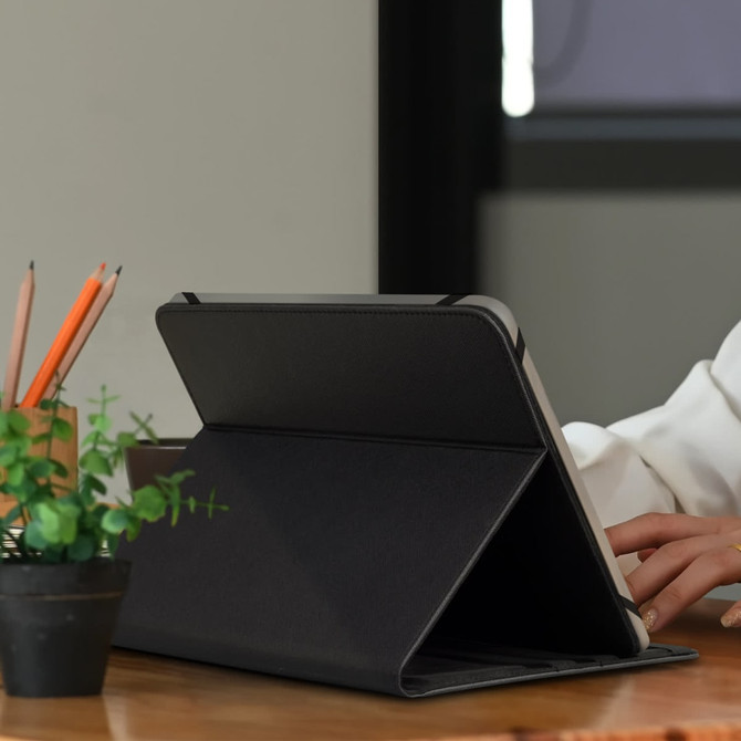 A black tablet case is positioned on a desk, with a potted plant and pencils visible in the background.