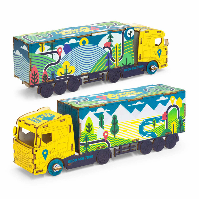 A large wooden model of a truck in bright yellow and multi-coloured designs, featuring a logo on the side.