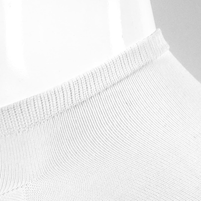A pair of white ankle socks featuring a ribbed cuff and a smooth texture, positioned on a reflective surface.
