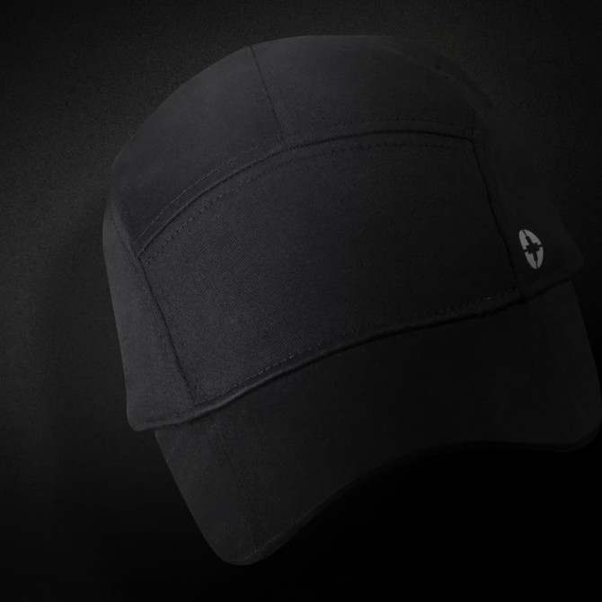 A black Swiss Peak 5 Panel Cap featuring a logo, displayed against a dark background.