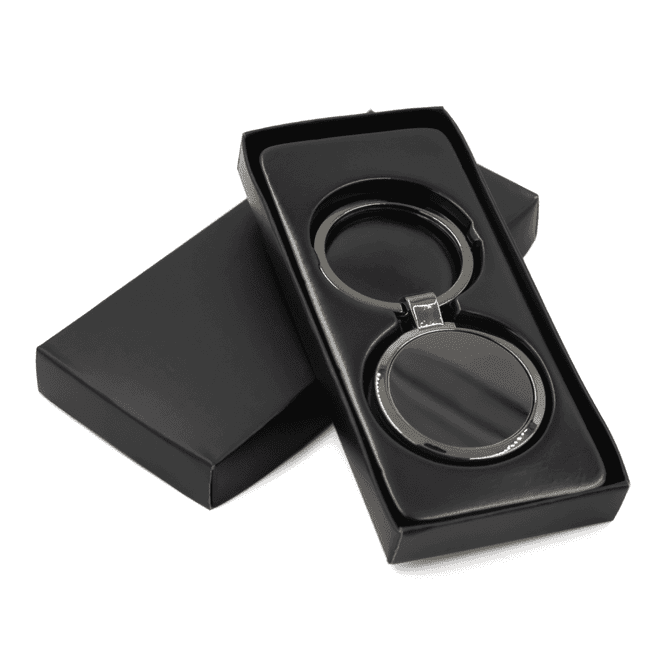 A gunmetal keychain presented in a black gift box, featuring a sleek, circular design.