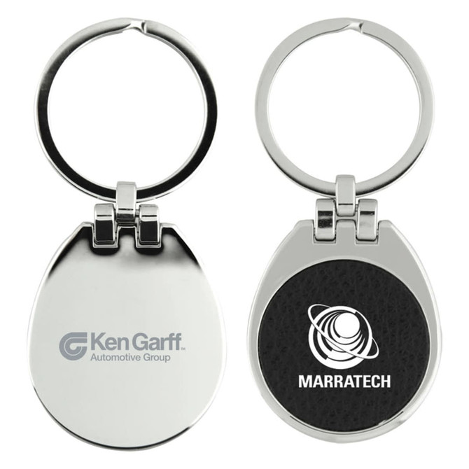 A metallic keychain with a circular ring and a flip top, featuring a textured black surface on one side and logos on both sides.