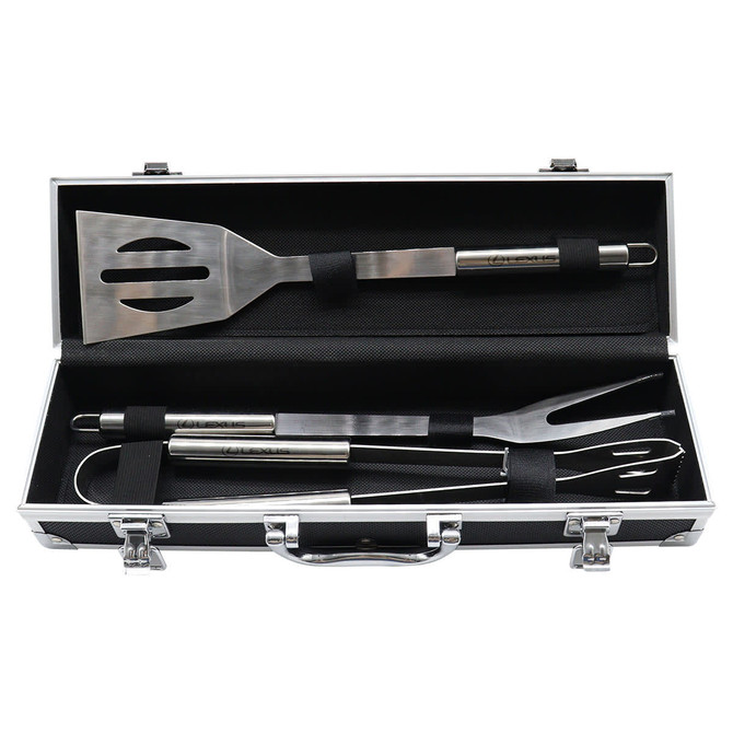 A stainless steel BBQ tool set including a spatula, fork, and tongs, housed in a black deluxe case with a handle.