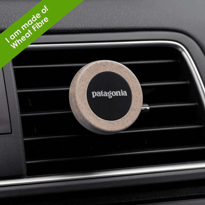 A round magnetic car vent mount in beige with a black centre, featuring a logo and made of plant fibre.