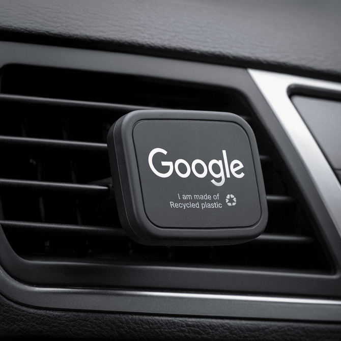 A rectangular black car vent mount featuring a logo, made from recycled plastic.
